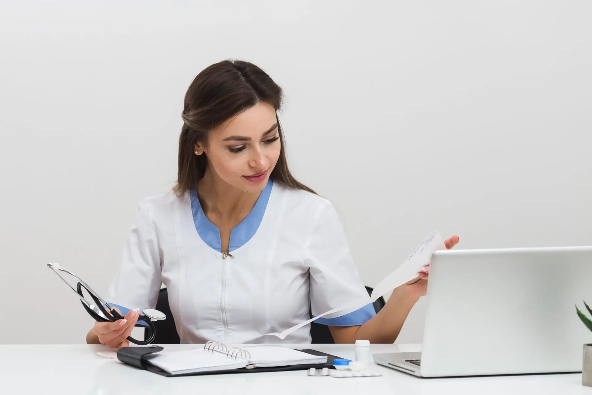 Médica revisando expedientes e informes en su consultorio